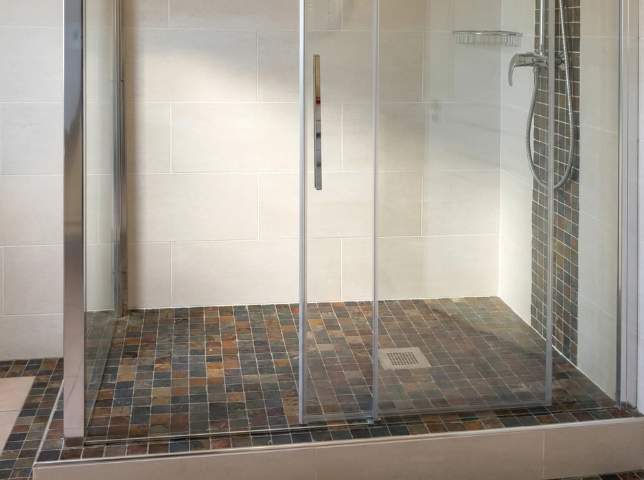 Salle de bain moderne avec douche à l'italienne vitrée, lavabo suspendu blanc et robinetterie chromée
