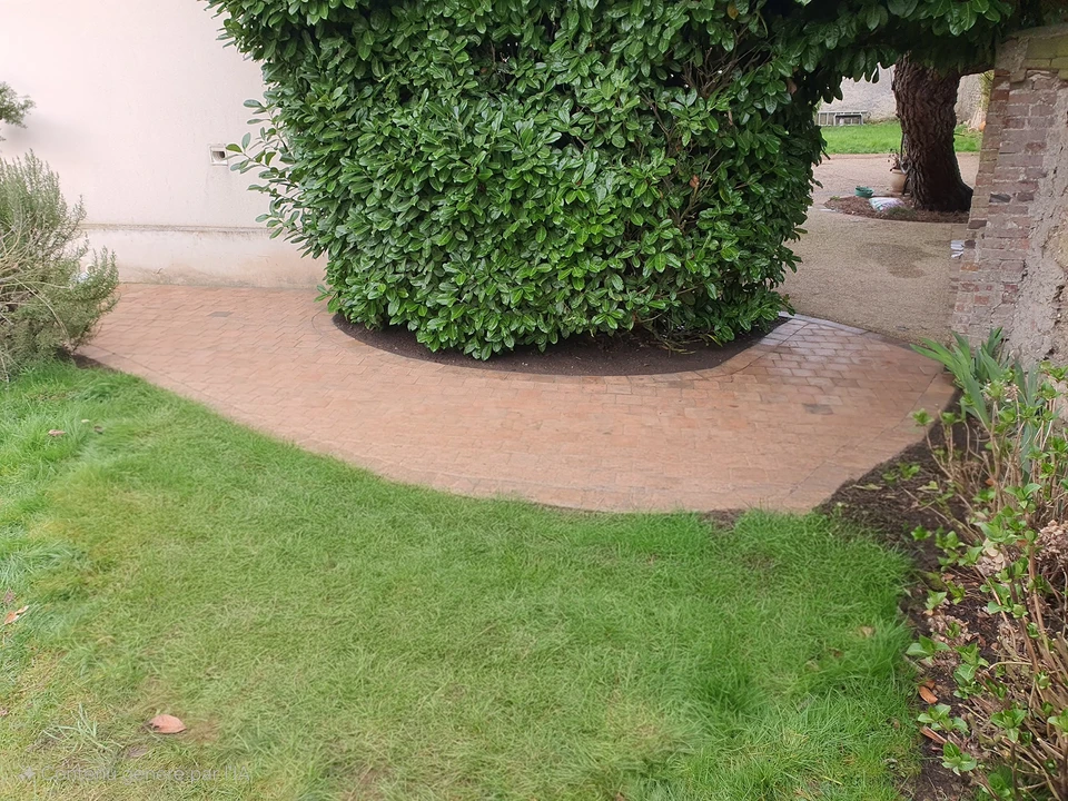 Portail double battant en aluminium thermolaqué gris anthracite (RAL 7016), monté entre deux piliers en parpaing