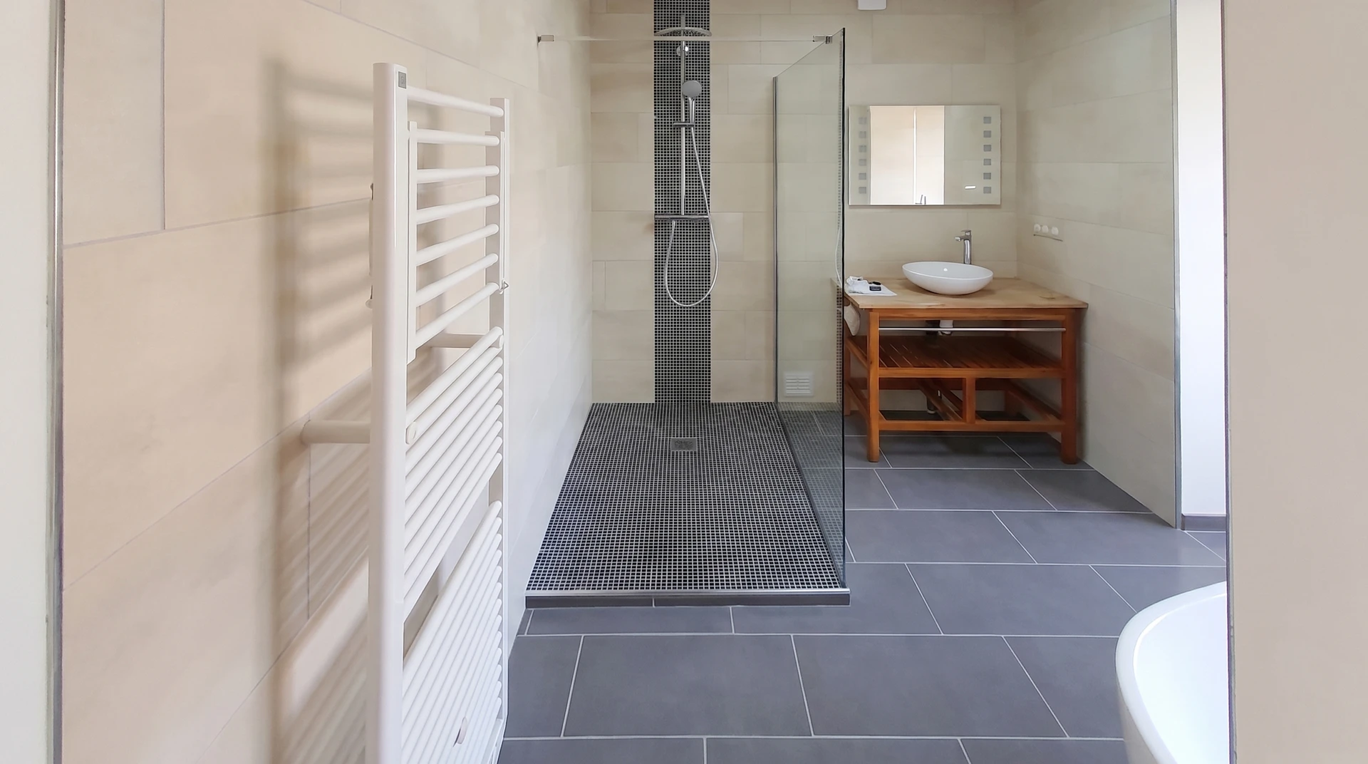 Salle de bain moderne avec douche à l'italienne vitrée, meuble vasque suspendu en bois naturel avec plan blanc, miroir encadré noir, luminaire géométrique suspendu