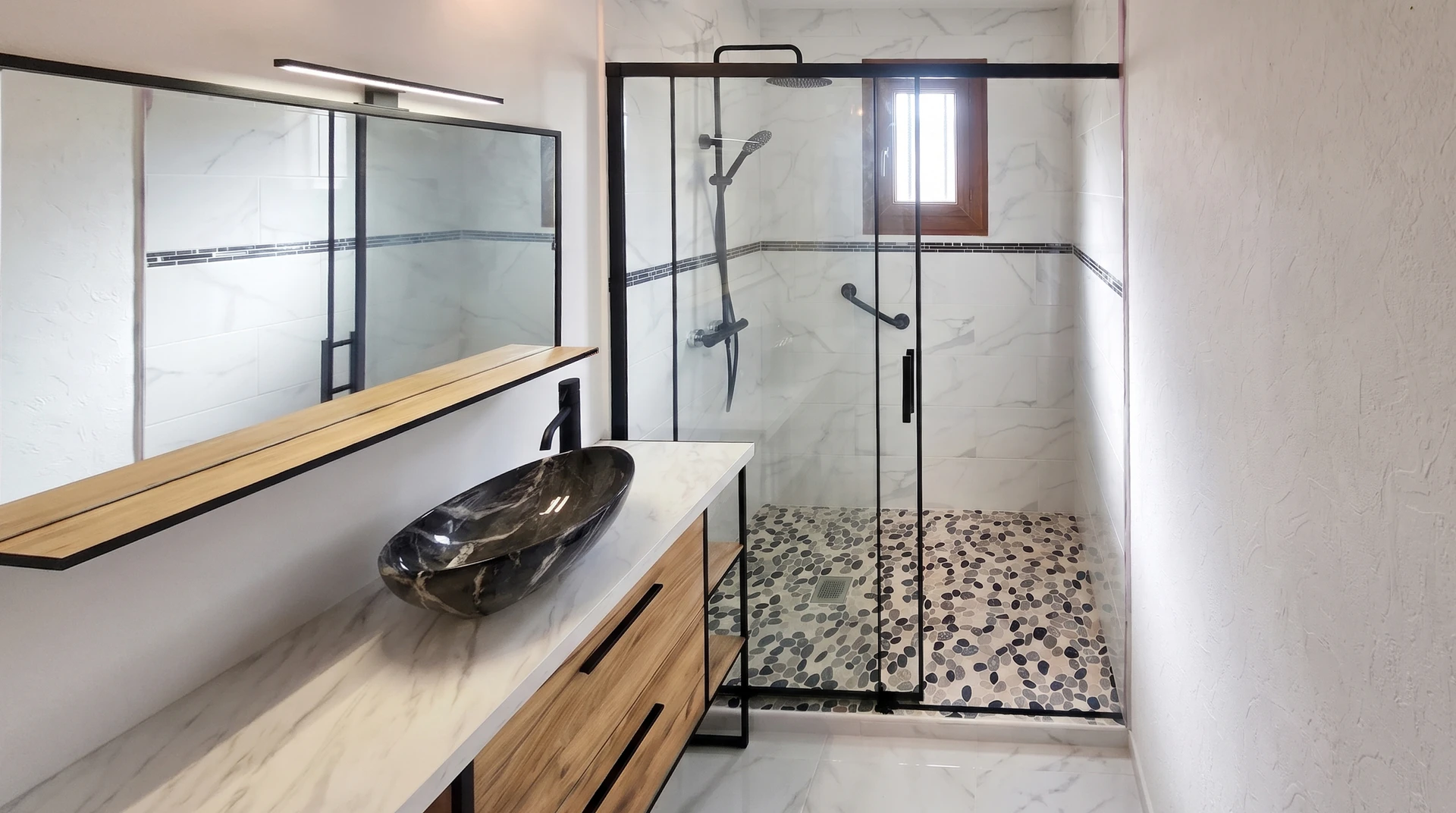Salle de bain moderne avec mur en briques de verre translucides, carrelage métro vert foncé brillant, meuble vasque suspendu en bois naturel avec plan vasque blanc intégré et robinetterie chromée